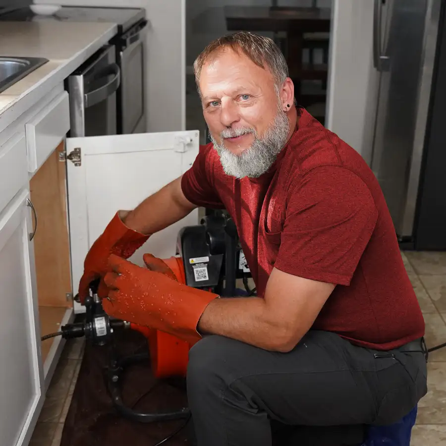 Plumber with plumbing equipment inspection a kitchen sink