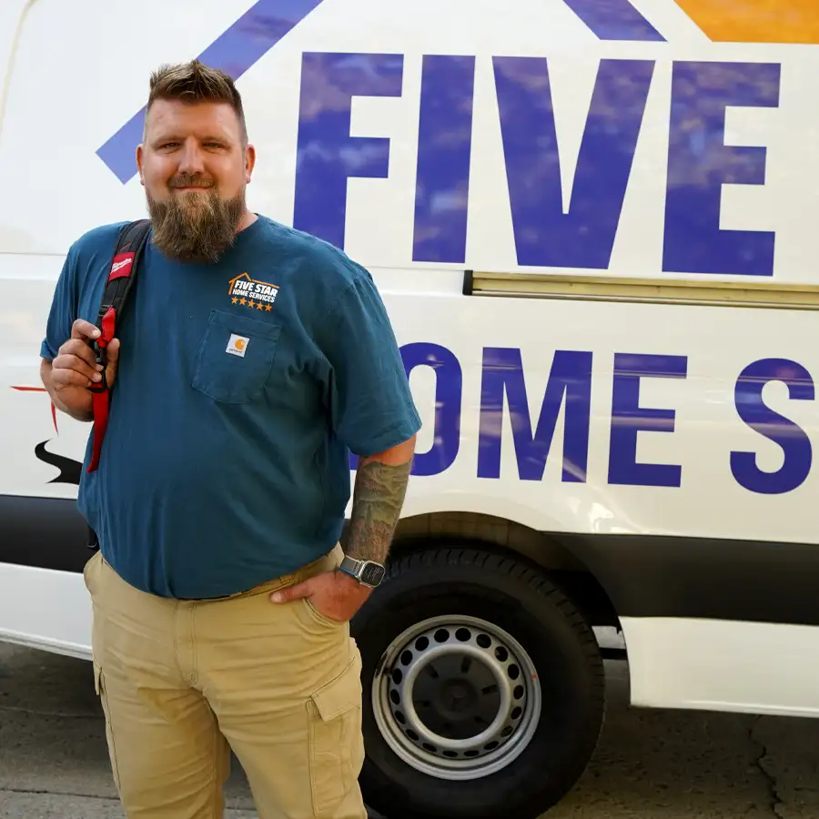 Plumber holding tools in front of a van that has the Five Star Home Services logo