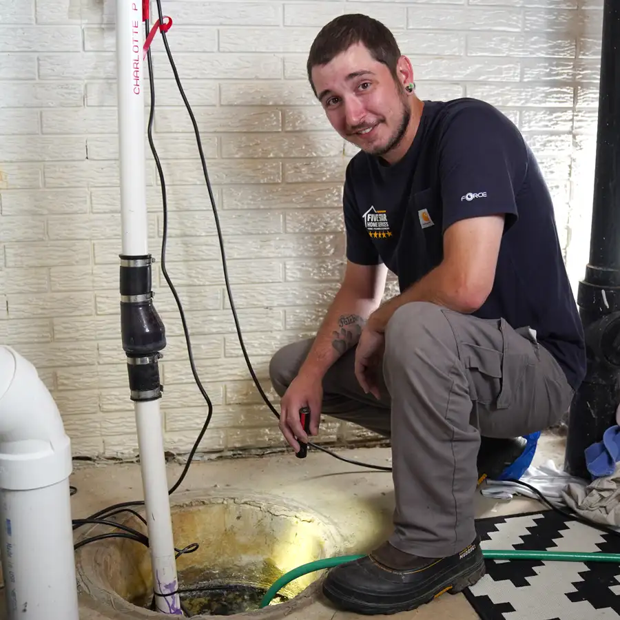 Plumber investigating a sump pump holding a flashlight