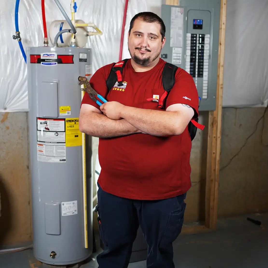 Plumber holding a wrench by a water heater