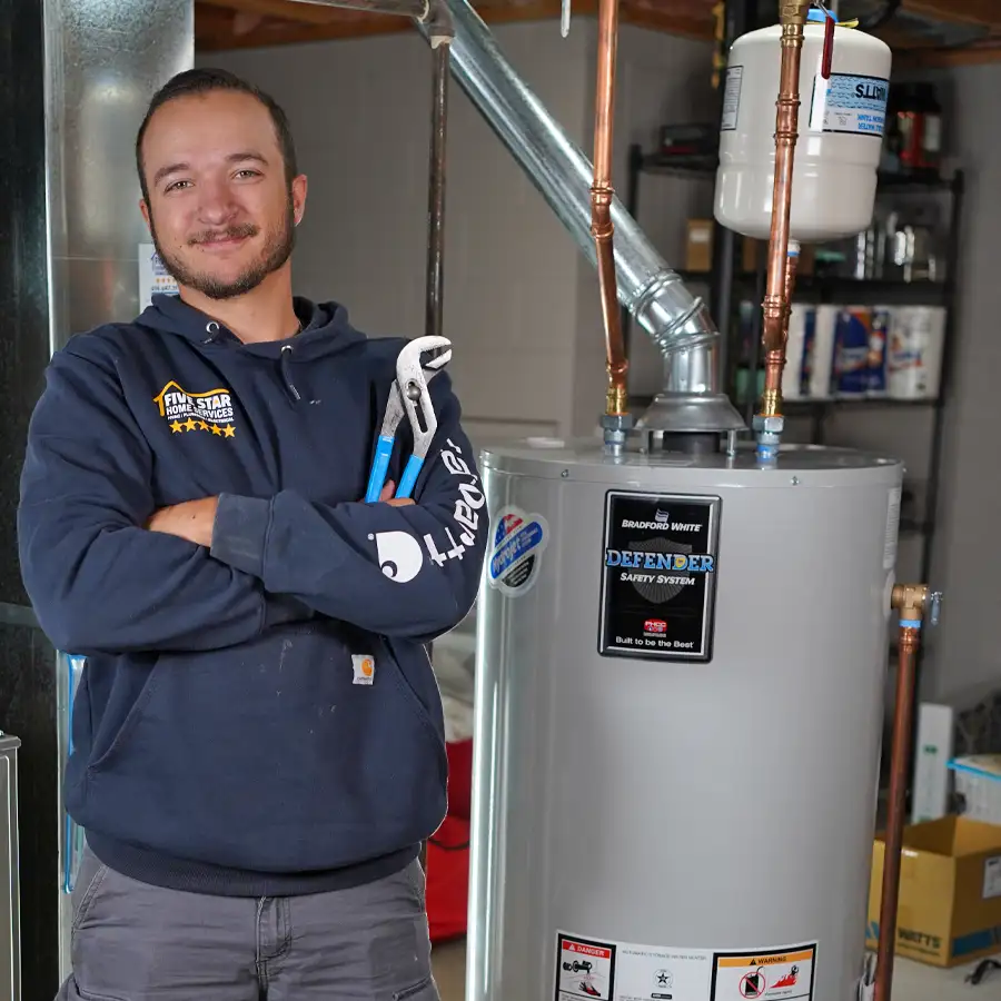 Plumber holding a wrench next to a water heater