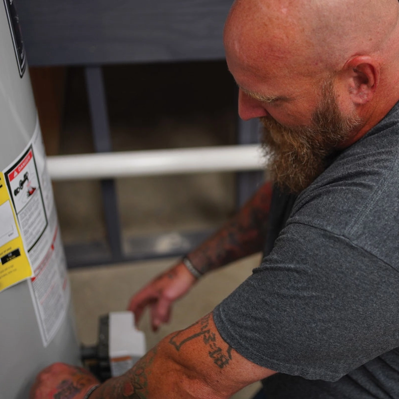 Plumber next to a water heater close up from the top 