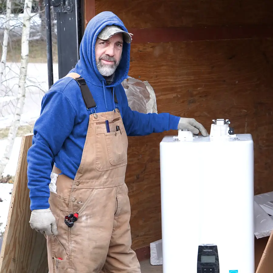 Plumber Outside Next to a Tankless Water Heater