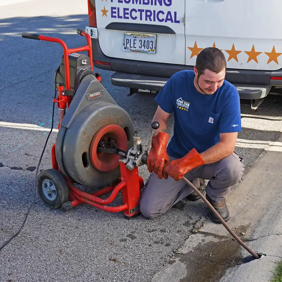 Plumber holding equipment inserted into a sewer